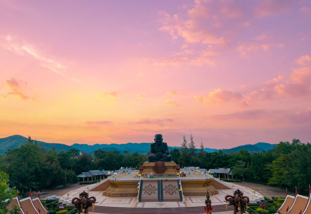 Learn English in Thailand: How the Country’s Leadership in Inclusive Tourism Inspires Dragon Study Tours 1 Learn English in Thailand at Hua Hin’s Huay Mongkol Temple, where students explore Thai culture beneath a stunning sunset and the statue of Luang Phor Thuad.